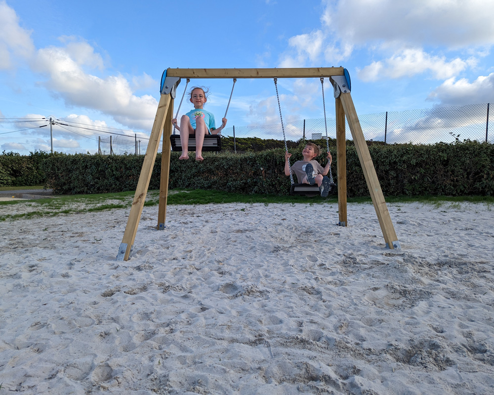 Enfans jouant sur une balançoire dans le sable