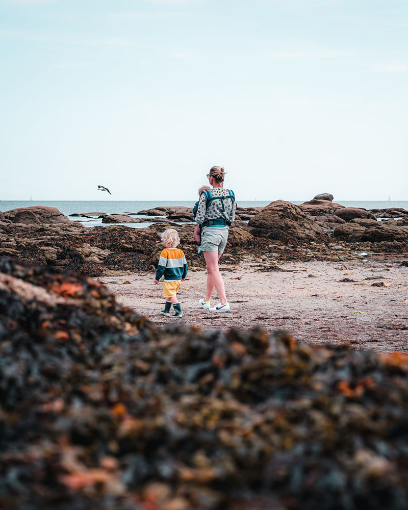 Femme et enfant marchant sur une plage de sable