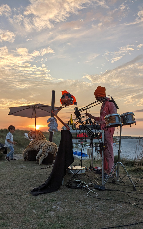 Musicien et son matériel en animation sur les dunes du Curnic à Guissény au coucher de soleil